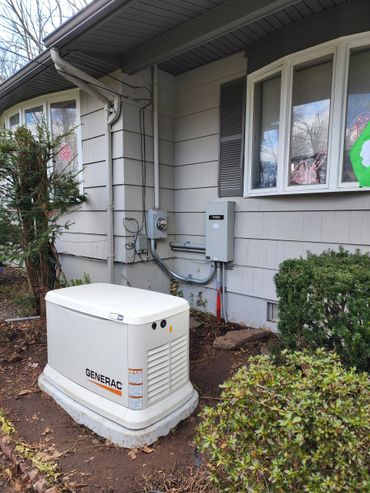 Generac standby generator installed outside a house near the utility box.