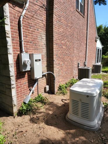 A residential brick wall with electrical panels and a Generac generator outside.
