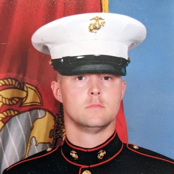 Portrait of a young Marine in uniform with a serious expression.