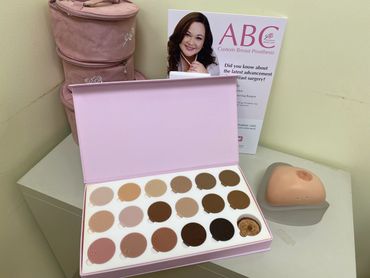 Custom breast prosthesis color samples and a prosthetic breast display on a table.