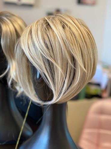 Blonde layered bob wig displayed on a black mannequin head.