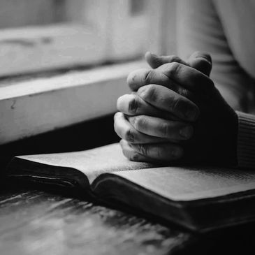 The hands of a reader atop at book being read.