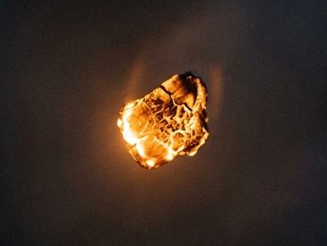 A glowing meteor burning in the dark sky.