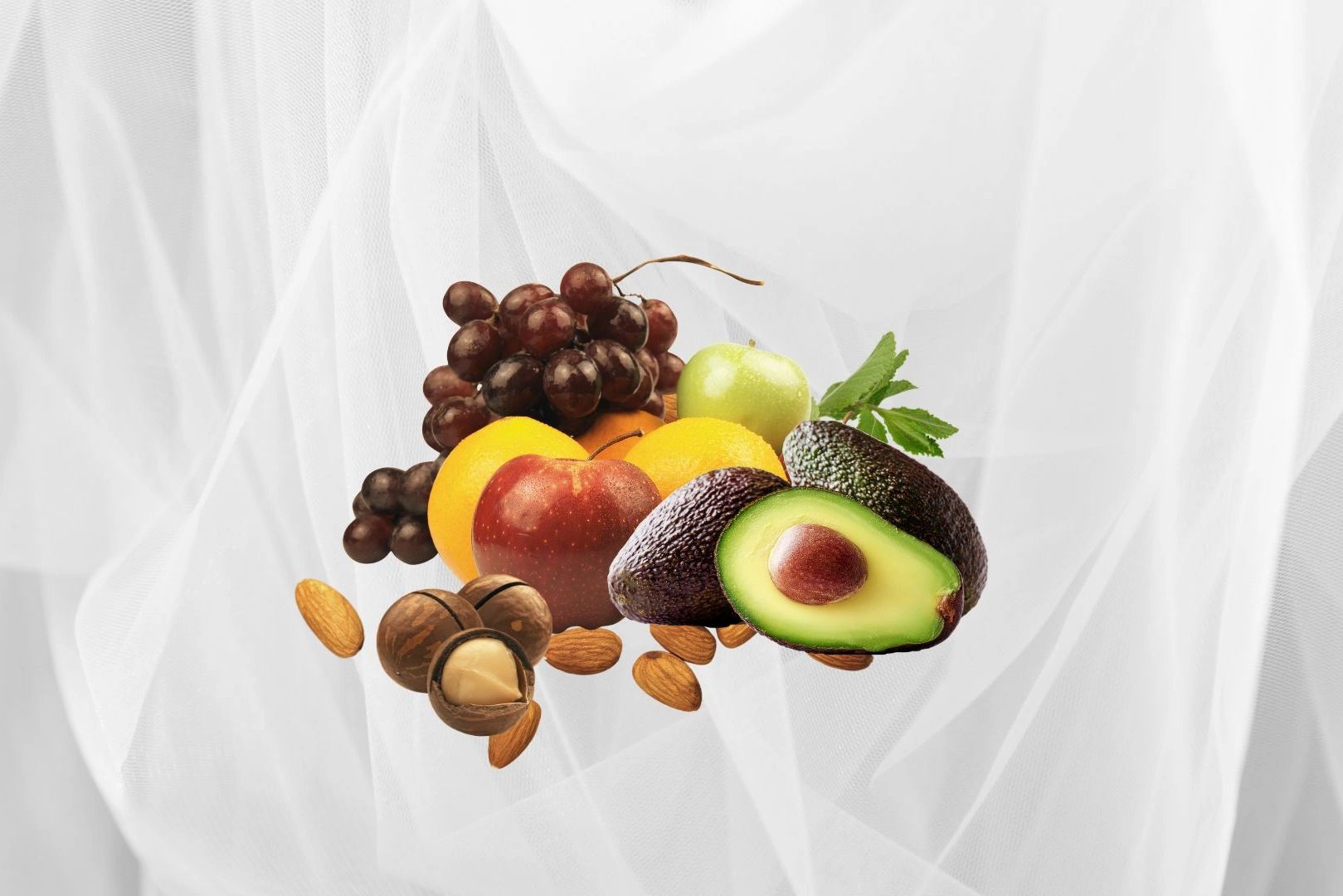 Assorted fresh fruits and nuts on a white background.