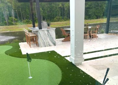 Covered lanai with outdoor kitchen, marble bar and backyard putting green on a preserve lot at a Tol