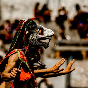 Person in a colorful traditional mask and costume performing.