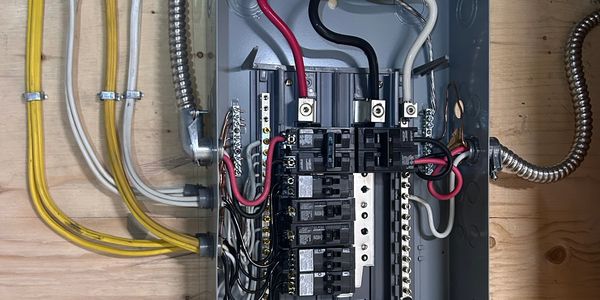 Open electrical panel with organized circuit breakers and wiring.