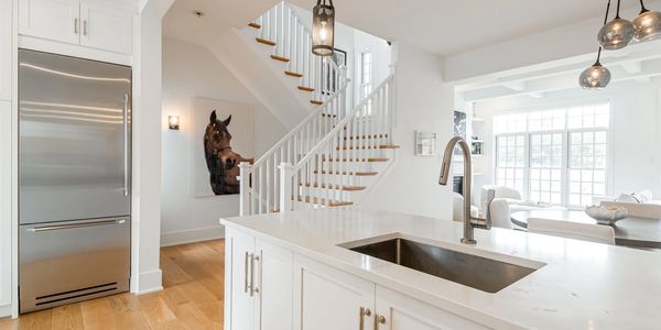 White Country shaker Kitchen with oak floors, stainless steel sub zero fridge, in Stone Harbor NJ