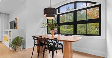 Cozy breakfast nook with black arched awning window, white trim, and natural light flooding the spac