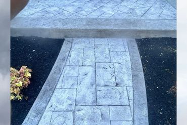 Concrete walkway with a step and landscaped sides.