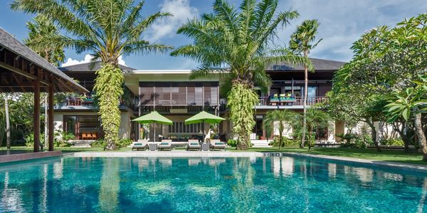 Luxurious villa with a swimming pool and palm trees.