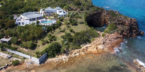 Luxury villa by the rocky coastline with swimming pool.