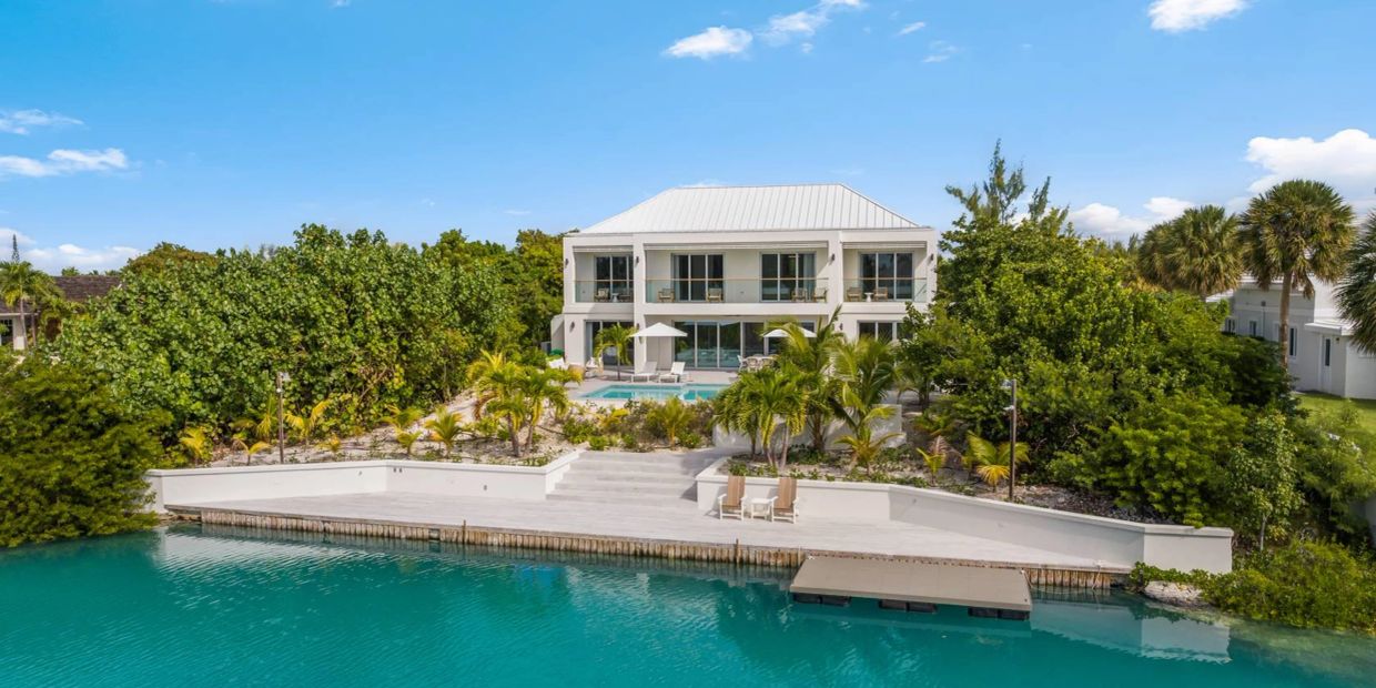 Modern waterfront house with pool and dock.
