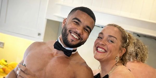 Smiling man in bowtie and a woman in black dress enjoying a party together.