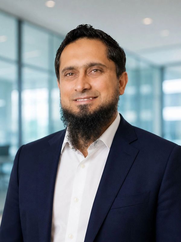 Man in a suit smiling with a beard.