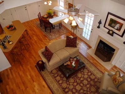 View of beautiful hardwood floors and fireplace from balcony bridge above
