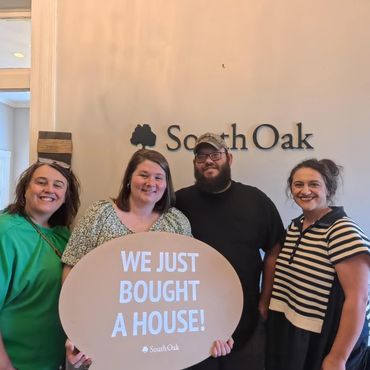 Happy group celebrating buying a new house with a South Oak sign.