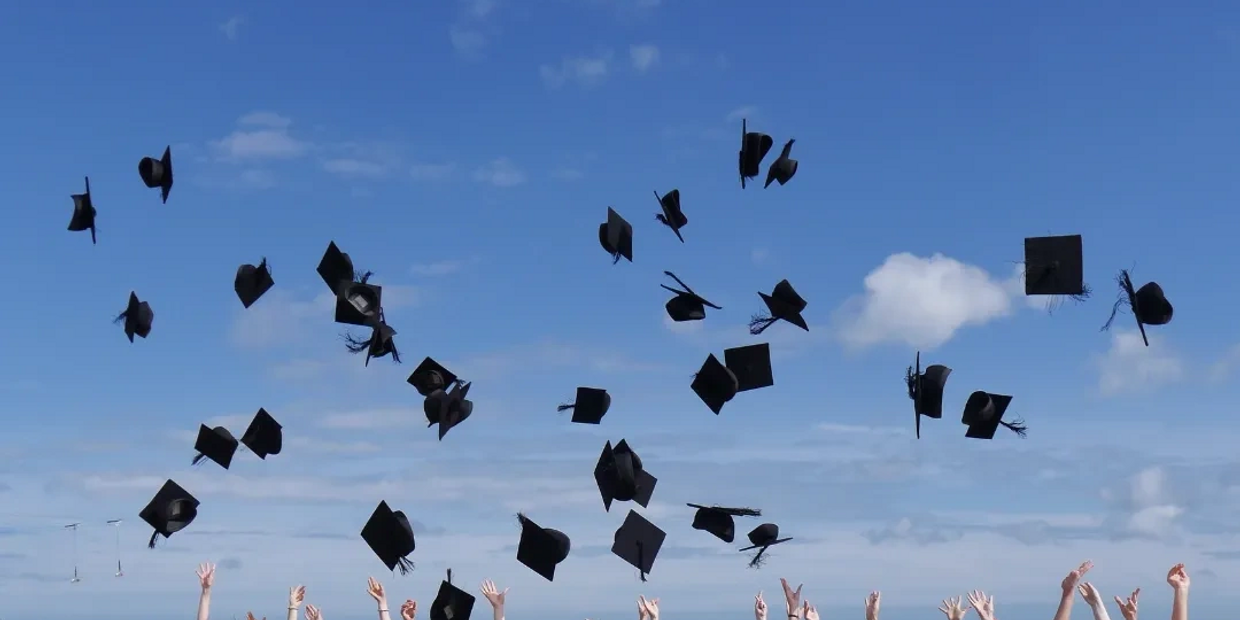 Graduates throwing their graduation caps in the air 