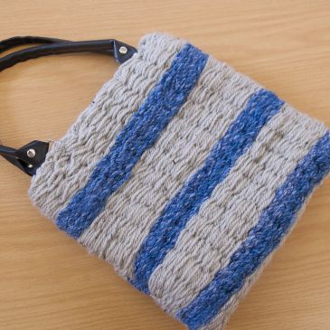 Handwoven knitted bag with blue and gray stripes.