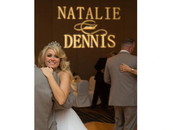 Bride smiling while dancing at wedding reception.
