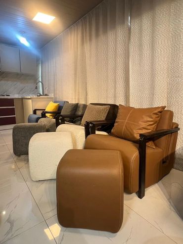 Row of modern armchairs with matching ottomans in a cozy living space.