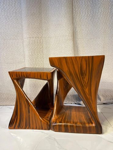 Two uniquely designed wooden tables with flowing, curved patterns.