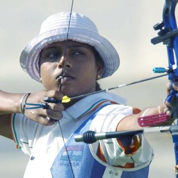 Archer aiming with intense focus, wearing a white hat and uniform.