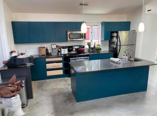 Modern kitchen with blue cabinets and a large island countertop.