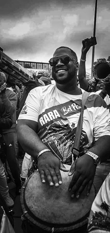 A Haitian musician name Bob Francois playing the drums with Rara Bel Poze at a parade in Boston