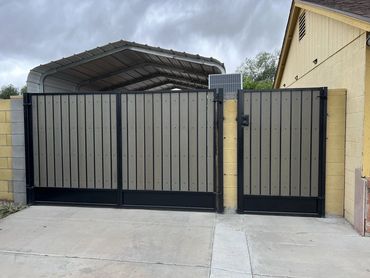 Wide gray-infill driveway gate and matching pedestrian gate in black metal frames