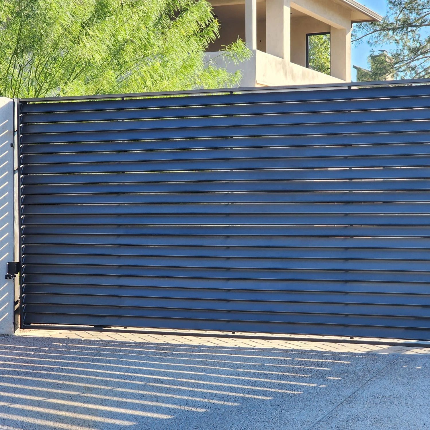 Finished horizontal metal gate between masonry columns