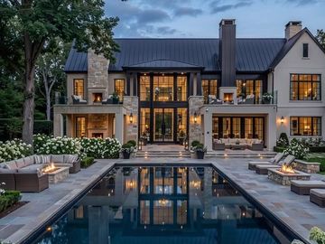 Large modern swimming pool with stone patio and fire pits.