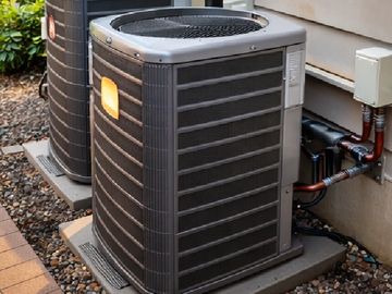 Modern exterior HVAC units installed on a gravel base.