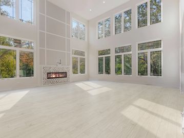 Bright living room with tall windows and herringbone fireplace.