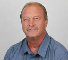 Middle-aged man in a blue shirt with UMO Baseball logo.