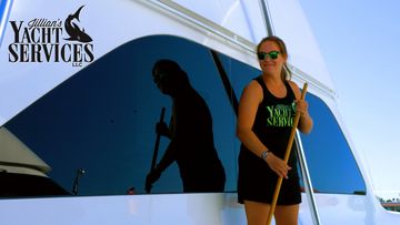 Woman cleaning yacht window with peace sign.