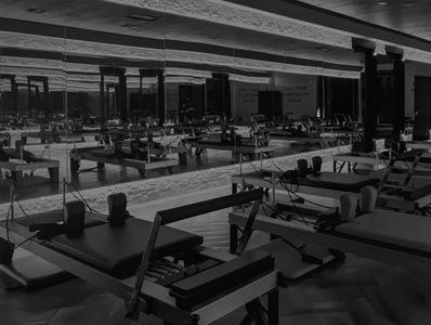 Empty Pilates studio with reformer machines.