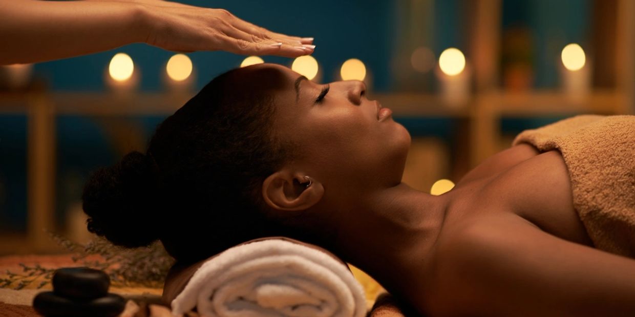Woman receiving a relaxing energy healing session in a spa setting.