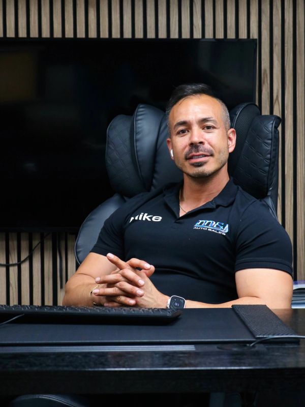 Man sitting confidently at a desk.