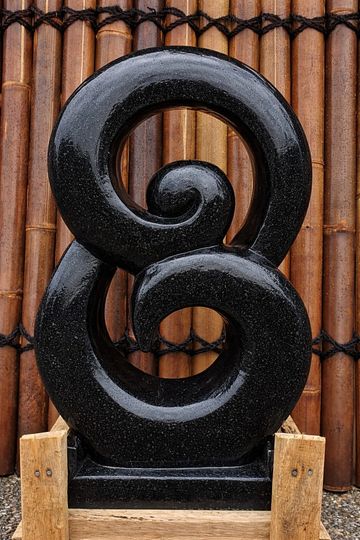 Black stone carving with spiral design.
