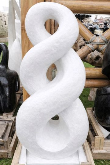 White abstract sculpture with intertwined loops.