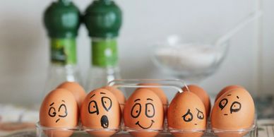 Eggs with various hand-drawn emotional faces on them.