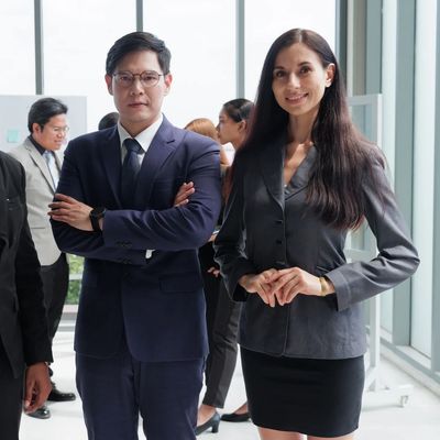 Confident business team in formal attire posing in a modern office environment.