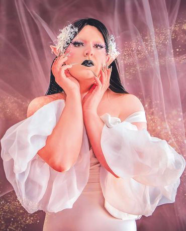 Surreal portrait of drag performer against textured backdrop, exploring beauty and vulnerability.