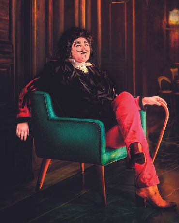 Portrait of drag king in tailored suit and confident pose, highlighting gender expression and artist