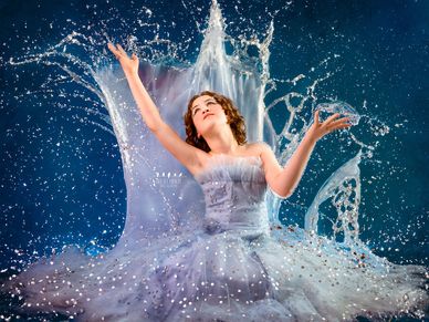 Fantasy-inspired portrait of a young woman emerging from water in a sparkling blue dress.