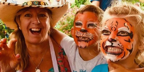 woman next to two kids with face paint on
