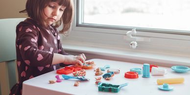 a girl playing with playdough.
