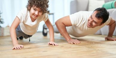 a boy and father doing pushups.