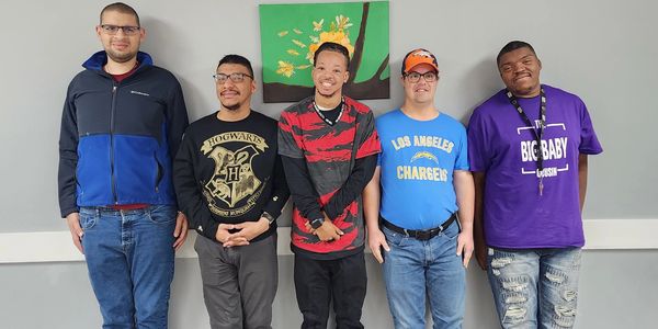 Group of OTB male participants smiling together inside OTB